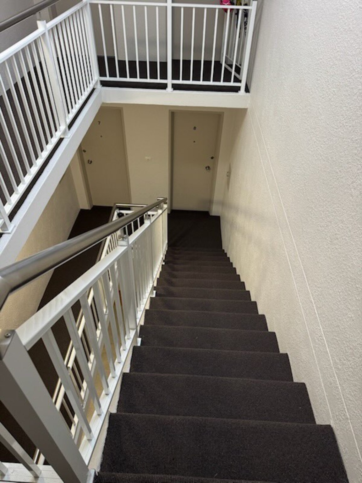 Completed charcoal carpet installation through a multi-level stairwell